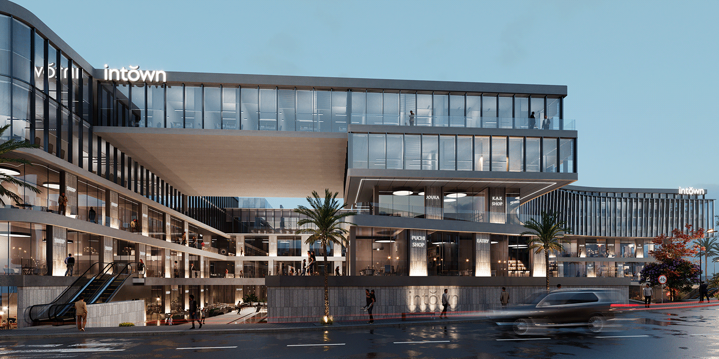 Moderno centro comercial con grandes ventanales curvos y palmeras iluminadas por la noche.